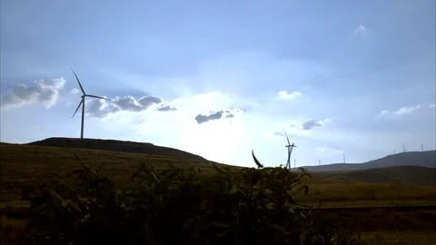 Time lapse shot of wind turbines on the top of the hill spinning at sunset with  Stock Footage 82083917