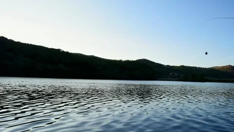 Time lapse showing night fall over flowing river, fishing rod enters a scene Stock Footage 263144943