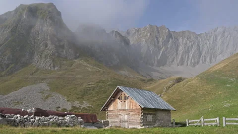 Time lapse showing play of light and shadows on mountain cabin in autumn Stock Footage 252613219