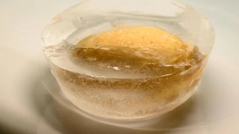Time-lapse that shows how ice cubes melt with a potato Stock Footage 115095734