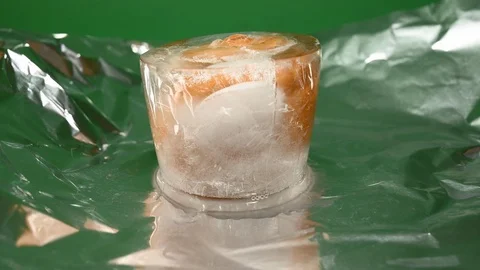 Time-lapse that shows how ice cubes melt with an egg inside Video stock 115097919