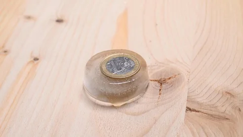 Time-lapse that shows how ice cubes melt with a coin Video stock 115117030