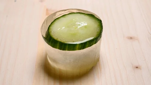 Time-lapse that shows how ice cubes melt with a cucumber inside Video stock 115120415