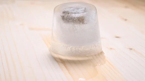Time-lapse that shows how ice cubes melt with a stone inside Stock Footage 115445461