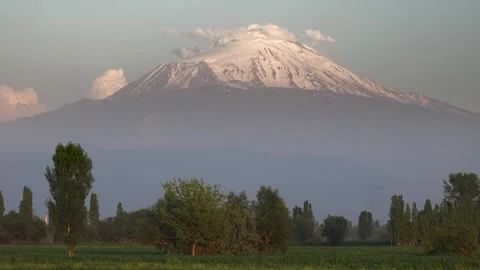 Time lapse shows the snowy peak of Mount Ararat rising beyond a green plain Stock Footage 339473478