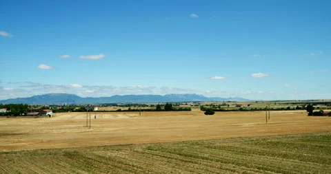 A time-lapse shows vast farmland beneath a blue sky. Video stock 341331353