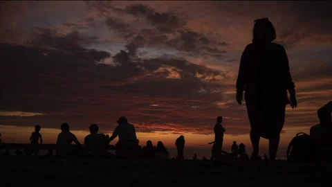 Time lapse of silhouettes of a crowd at sunset on the beach fade out. Stock Footage 232423863