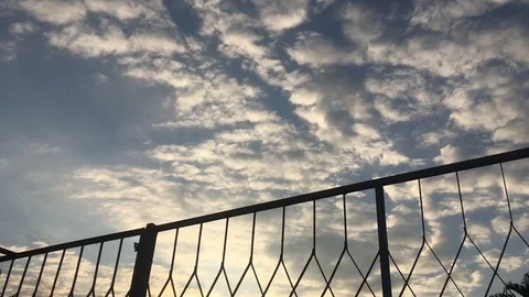 Time lapse sky clouds mesh fence sunset Stock Footage 118264130