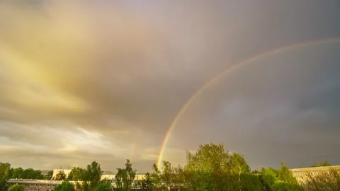 Time lapse sky with floating clouds and a rainbow in the sky during rain. Ama Stock Footage 155994140