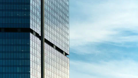 Time-lapse skyscraper facade, blue sky clouds reflected on windows glass surface Stock Footage 195127219