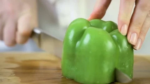 Time-lapse. Slicing green bell pepper on a wood cutting board. Vídeos de archivo 76376243