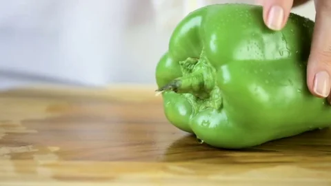 Time-lapse. Slicing green bell pepper on a wood cutting board. Vídeos de archivo 76376500