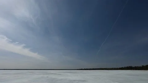 Time lapse of slow moving wispy cirrus clouds in a blue sky over a large lake Stock Footage 152571538