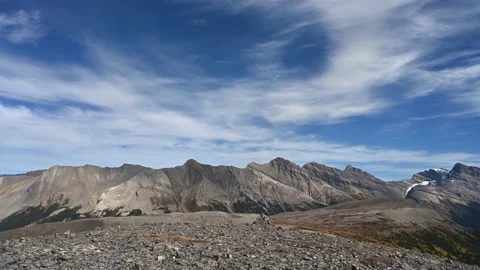 Time lapse of slow moving wispy white clouds in a blue sky above mountain scene Stock Footage 223537062