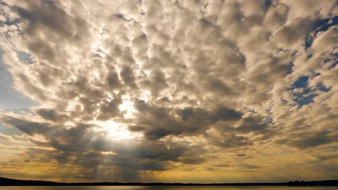 Time lapse. Slow. Sunrays shining from the blue and yellow sky through clouds Stock Footage 111157456