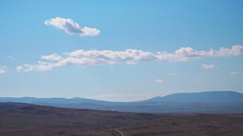 Time lapse of small beautiful clouds that melt in the sky above the mountains Stock Footage 104835211