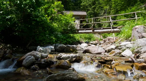 Time lapse - small river in the mountain with a small wood bridge Видео 58622999
