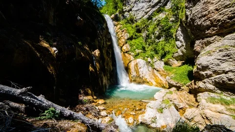 Time Lapse - Small waterfall floating through an idyllic landscape in the alps Stock Footage 99353385