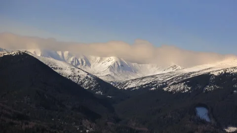 Time-lapse of snow-covered mountain peaks with moving clouds at sunrise Stock Footage 304048674