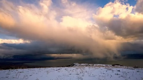 Time lapse of a snowy landscape and lake beneath dramatic clouds Stock-Footage 341328779