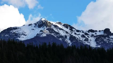 Time-lapse of snowy mountain peak near Troyan with moving clouds Stock Footage 318909312