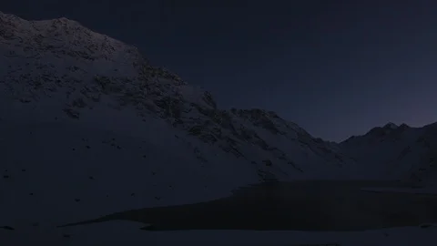 Time-lapse of snowy mountains and a frozen lake at sunrise Stock Footage 113246531