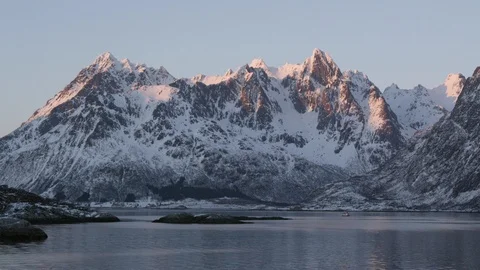 Time-lapse of snowy mountains over an icy water at sunset Stock Footage 113229434