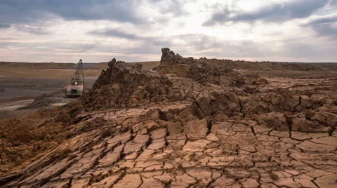 Time lapse. Сracked soil. Sun rays throgh the sky. Drag-line excavator loads Stock Footage 64510507