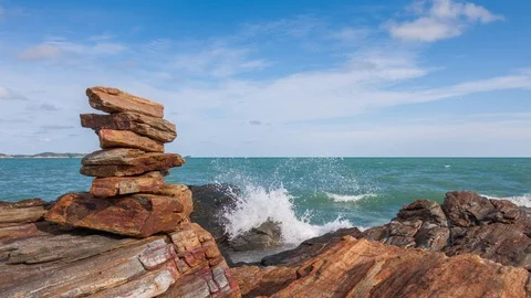 Time lapse of stacking stone balance beside water splash from sea day , Zoom in. Stock Footage 113342515