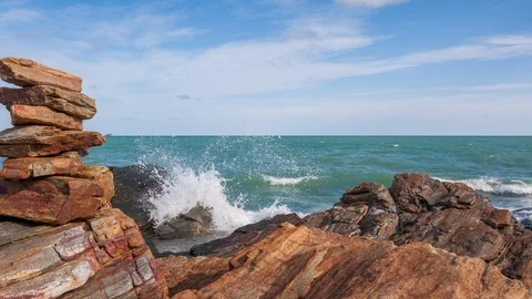 Time lapse of stacking stone balance beside water splash from sea day , Panning Stock Footage 113342569