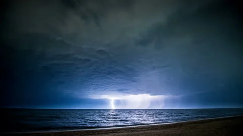 Time-lapse. Starry night with thunderstorm and lightning over the sea Stock Footage