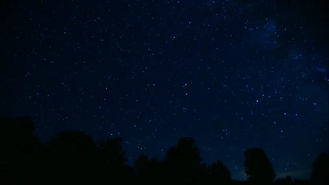 Time lapse of starry night time sky with shooting stars and silhouetted 動画素材 120393509