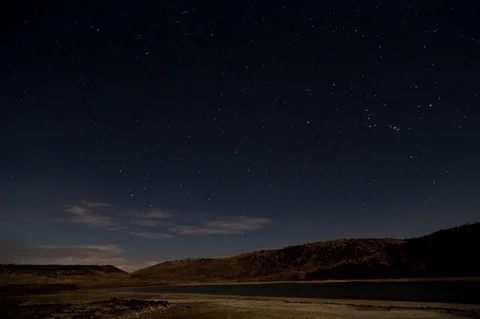 Time lapse stars and clouds passing at a lake in the mountains Stock Footage
