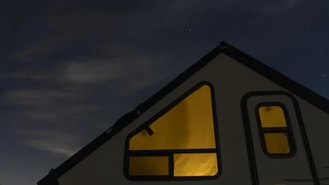 Time lapse of stars and clouds over a RV camper on a peaceful night Stock Footage 220469458