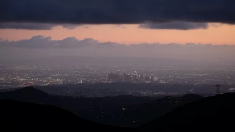 Time lapse of storm clouds and pink sky over hills and a distant Los Angeles Stock Footage 103230437