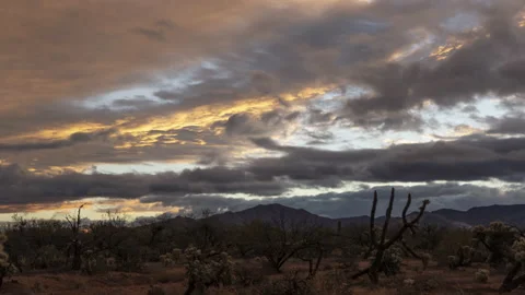 Time lapse of storm clouds over a desert landscape at sunrise Stock Footage 225502457