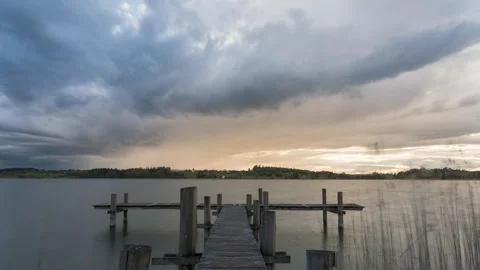 Time-lapse of storm clouds, sunshine, and rain. Shot from a pier on the lake Stock Footage 307612391