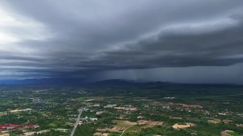 Time-lapse of storm front rolling over farmland with distant roads and villages Stock Footage 312538625