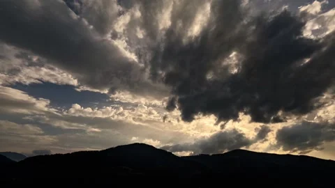 Time lapse of stormy clouds over sunny hills Video stock 315783729