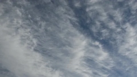 Time lapse of streaky white clouds moving through a bright blue sky. Stock Footage 139349345
