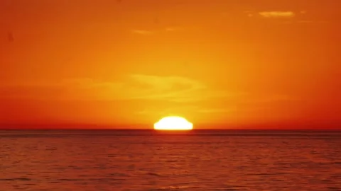 Time lapse of a stunning sunset over the ocean with the sun slowly dipping .. Stock Footage 283485021