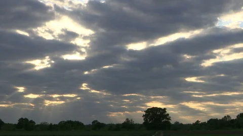 TIME LAPSE - the sun behind the clouds with rays of light Stock Footage 129881588