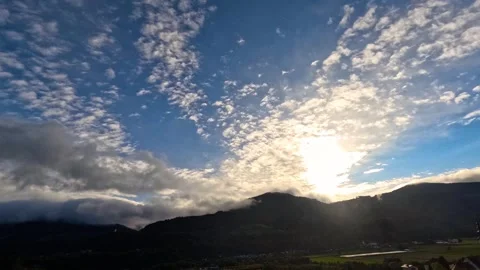 Time lapse of sun behind clouds with mountains Stock Footage 318449541