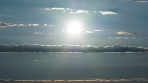 Time lapse of sun descending between flat clouds moving with parallax effect Stock Footage 111399866