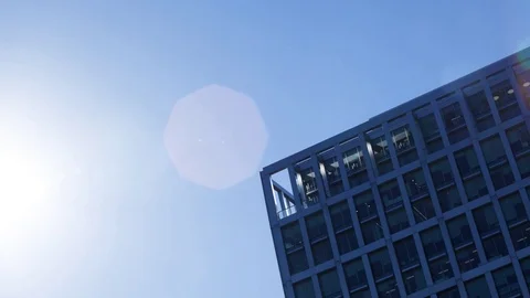 Time-lapse of the sun disappearing behind a modern office block in the afternoon Stock Footage 71099605