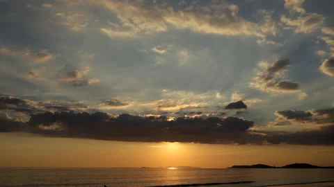 Time-lapse of the sun emerging from behind clouds before slowly 스톡 동영상 324958226
