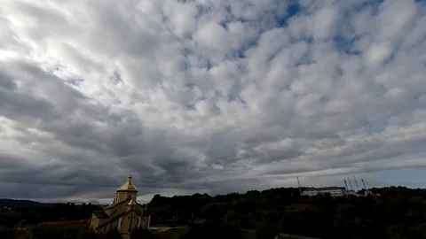 Time lapse: the sun hidden behind fluffy clouds flying in the sky. Stock Footage 129268350