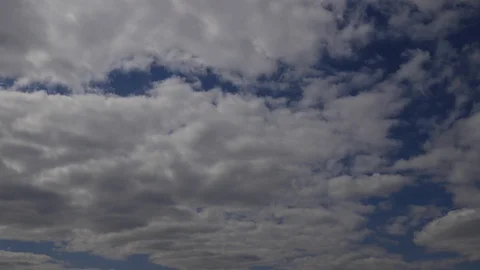 Time lapse: the sun hidden behind fluffy clouds flying in the sky. Stock Footage 129637310