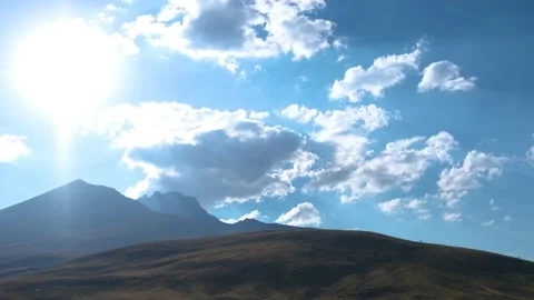 Time Lapse of Sun Movement in Crystal Clear Sky with Clouds Over Mountain Top 動画素材 204860716
