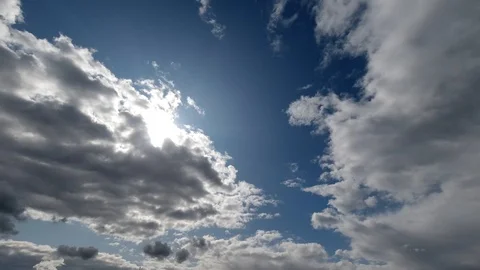 Time lapse: sun rays brake through fluffy clouds flying in the sky. Stock Footage 129269062